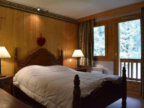 een slaapkamer met een bed, 2 lampen en 2 ramen bij Appartement Méribel, 3 pièces, 6 personnes - FR-1-180-129 in Méribel
