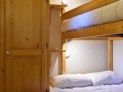 a bedroom with two bunk beds and a door at Appartement Méribel, 3 pièces, 5 personnes - FR-1-180-122 in Méribel