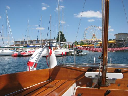 ein Boot im Wasser mit einem Riesenrad im Hintergrund in der Unterkunft Ferienwohnungen im Hafen Pier1 am Cospudener See bei Leipzig in Markkleeberg
