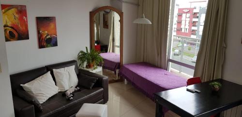 sala de estar con sofá, mesa y ventana en Departamento céntrico en Villa Carlos Paz