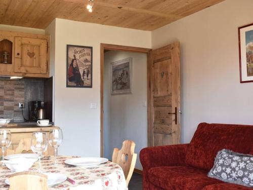 un salon avec une table et un canapé rouge dans l'établissement Appartement 3 pièces proche pistes avec balcon et ski-room - FR-1-180-153, à Méribel