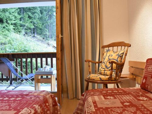 - une chambre avec un lit, une chaise et un balcon dans l'établissement Appartement cosy 3 pièces, 6 pers, Méribel - Balcon Sud, parking, proche pistes et commerces - FR-1-180-151, à Méribel