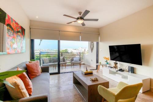 a living room with a couch and a flat screen tv at Cocos 403 at Arenis in Playa del Carmen