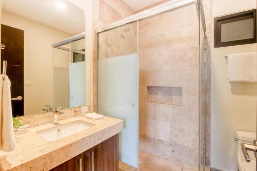 a bathroom with a sink and a shower at Cocos 403 at Arenis in Playa del Carmen