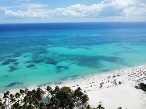 an aerial view of a beach with people and the ocean at Cocos 403 at Arenis in Playa del Carmen