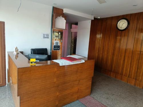 una oficina con recepción con reloj en la pared en Om hotel, en Rohtak