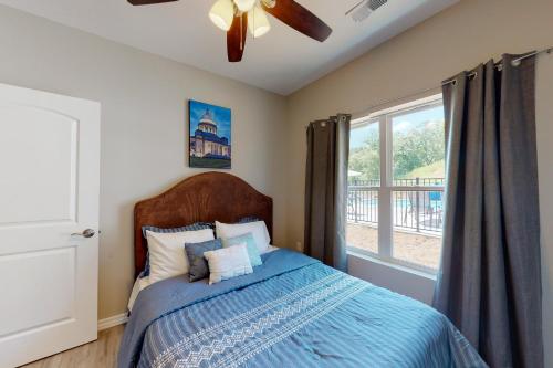 a bedroom with a bed with a ceiling fan and a window at Vinyards Terrace 3112 S Vineyards Terrace 1 in Branson