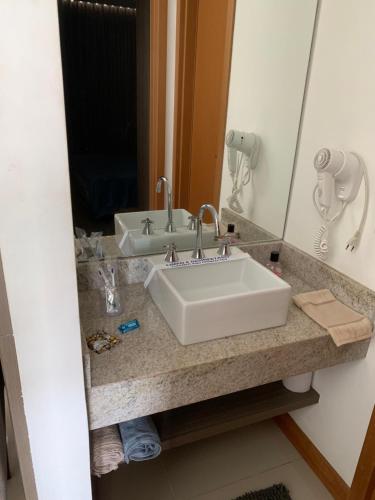 y baño con lavabo blanco y espejo. en Flat moderno e sofisticado, en Río de Janeiro