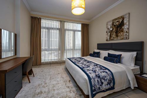 a bedroom with a bed and a desk and a television at Al Gassar Resort in Doha