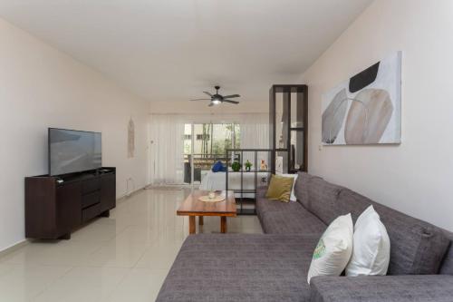 sala de estar con sofá y TV en Affordable 1 Bedroom Condo For Families - Near 5th, en Playa del Carmen
