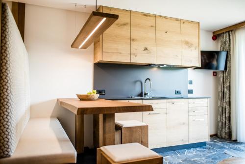 a kitchen with a wooden table and a sink at Garni Residence Soraiser in Selva di Val Gardena