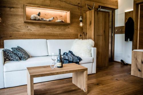 a living room with a white couch and a table at Garni Residence Soraiser in Selva di Val Gardena