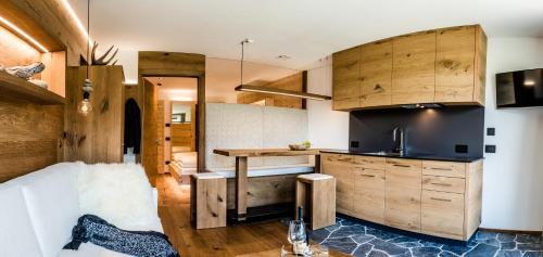 a kitchen with wooden cabinets and a table in a room at Garni Residence Soraiser in Selva di Val Gardena
