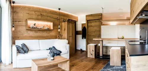 a living room with a white couch and a kitchen at Garni Residence Soraiser in Selva di Val Gardena