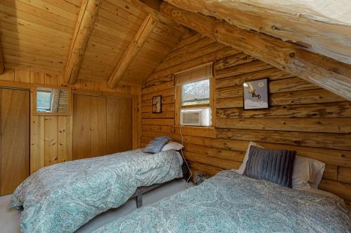 1 dormitorio con 2 camas en una cabaña de madera en Hartland Cabin en Hartland