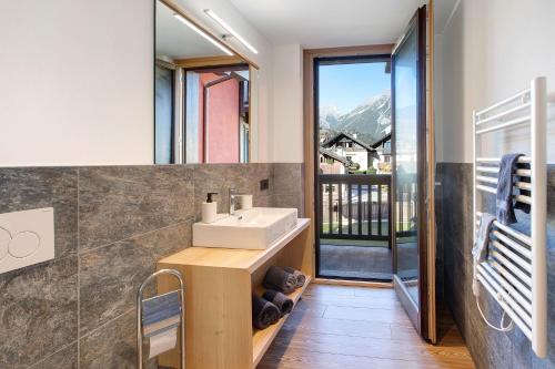 uma casa de banho com lavatório e uma varanda com vista em Olympic Chalet 11 em Bormio