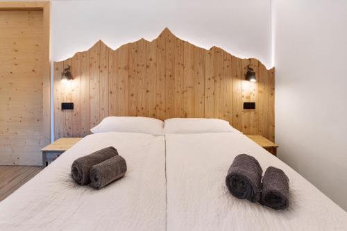 um quarto com uma cama branca com duas toalhas em Olympic Chalet 11 em Bormio