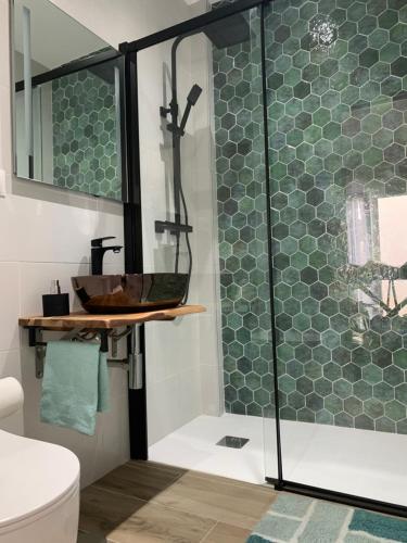 Un baño con ducha de cristal con lavabo. en Apartamento Home Paradaise, en Benajarafe