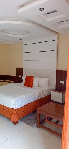 a bedroom with a large bed and a table at Meru Slopes Hotel in Meru