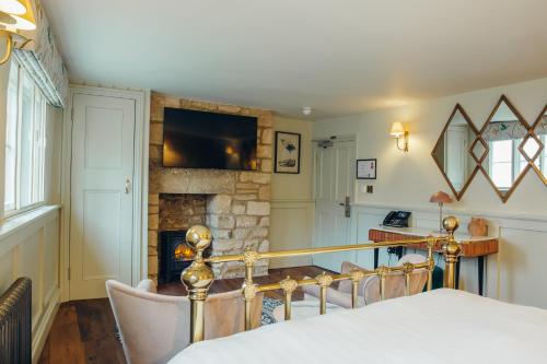 a dining room with a table and a fireplace at Crown Hotel in Stamford