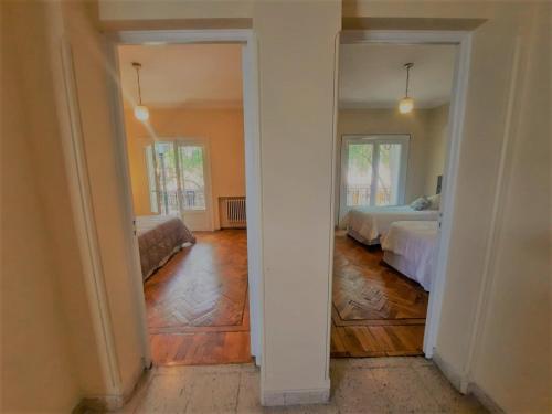 an empty room with two beds and a hallway at La Rufina B&B in Mendoza