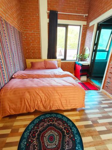 a bedroom with a bed and a brick wall at Du Gia View Homestay in Làng Cac