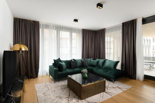 a living room with a green couch and a table at Emerald Downtown Luxury Suites by Continental Group in Budapest