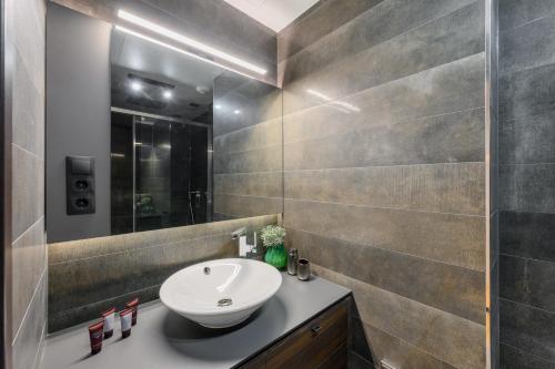 a bathroom with a sink and a mirror at Emerald Downtown Luxury Suites by Continental Group in Budapest