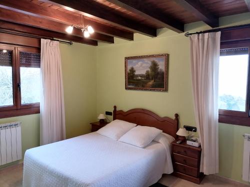 a bedroom with a white bed and two windows at Pikua Landetxea in Mutriku