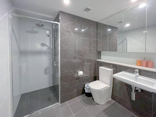 een badkamer met een douche, een toilet en een wastafel bij Amazing 2 Bedroom in CBD! in Brisbane