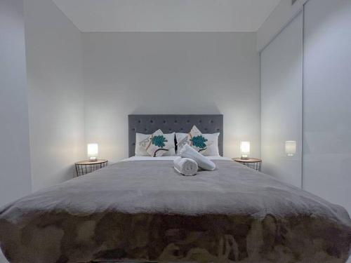 een slaapkamer met een groot bed met 2 lampen bij Amazing 2 Bedroom in CBD! in Brisbane