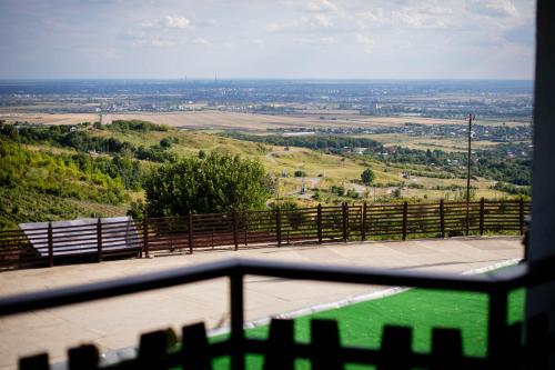 a view of a field from a balcony with a bench at Casa Seciu in Ploieşti