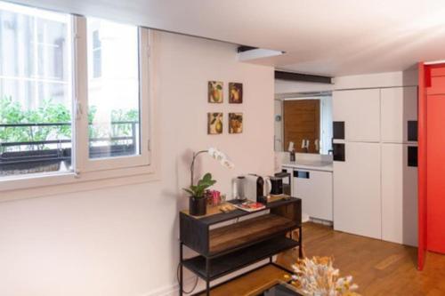 - une cuisine avec un réfrigérateur et une table dans la chambre dans l'établissement Haut MaraisJolie duplex 33m2…, à Paris