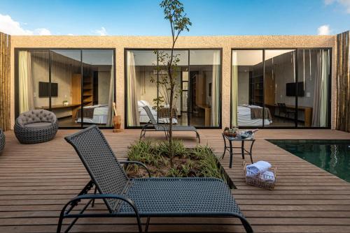 a patio with two chairs and a swimming pool at Uhane Luxury Villas in São Miguel do Gostoso