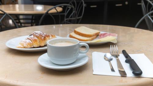 a table with a cup of coffee and a plate of bread at Hotel Center 2 in Rome