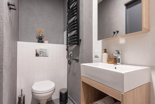 a bathroom with a white sink and a toilet at SHED Vilnius Coliving in Vilnius