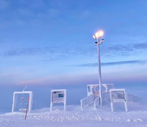 a beach with a light pole and chairs in the snow at Arctic Lodges Lapland Ski In Family Studio, Wi-Fi, National Park - Lapland Villas in Pyhätunturi
