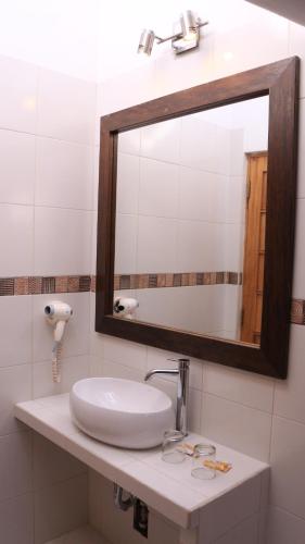 ein Badezimmer mit einem weißen Waschbecken und einem Spiegel in der Unterkunft Amaru Colonial in Cusco