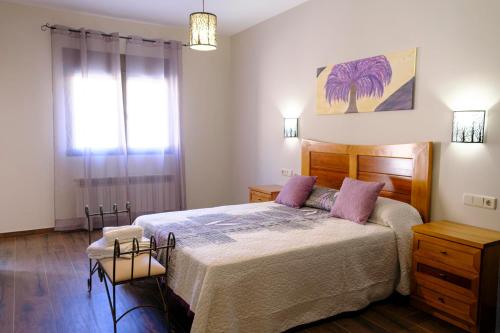 a bedroom with a large bed with pink pillows at Casa Rural Cristina 
