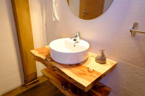 a bathroom with a white sink and a mirror at Casa Rural Cristina in Morcuera