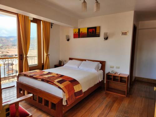 ein Schlafzimmer mit einem Bett und einem großen Fenster in der Unterkunft Amaru Colonial in Cusco