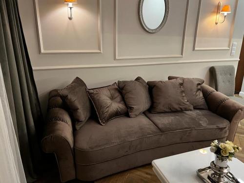 a brown couch in a living room with a table at Family & Business Sauna Apartments Sienkiewicza No1 Centrum Plac Lliteratów- Piękny Apartament - 1 Bedroom with Private Sauna, Bath with Hydromassage, Parking in Kielce