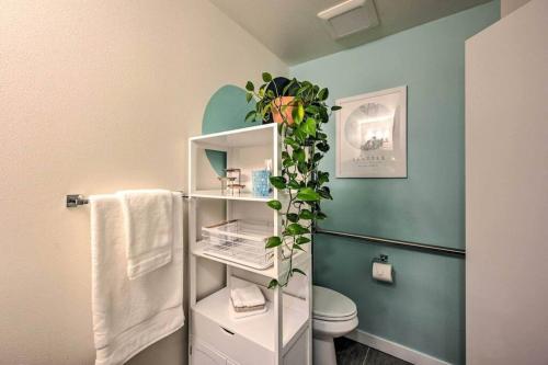 a bathroom with a toilet and a shelf with a plant at Stylish Ballard studio 15 mins from Space Needle in Seattle