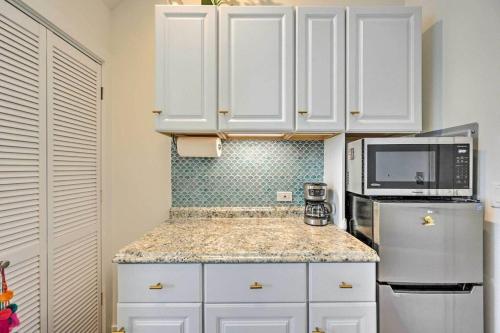 a kitchen with white cabinets and a refrigerator at Stylish Ballard studio 15 mins from Space Needle in Seattle