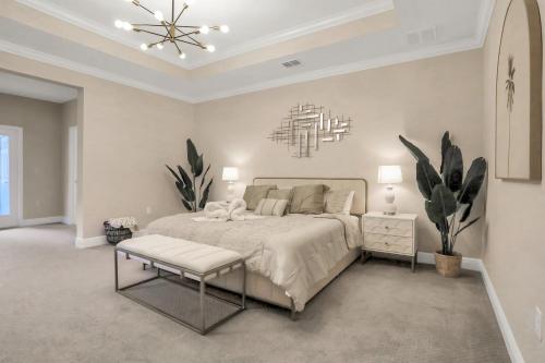 a white bedroom with a bed and a chandelier at Newport Retreat in Tampa
