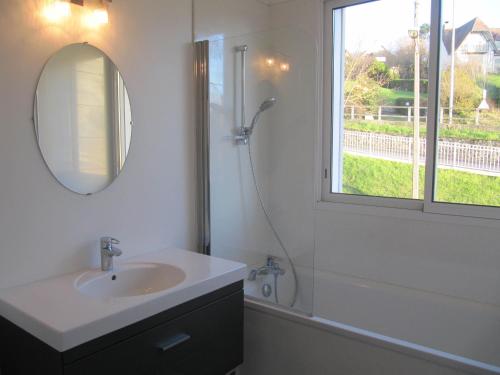 トゥルヴィル・シュル・メールにあるVilla Réginaのバスルーム(シンク、シャワー、鏡付)