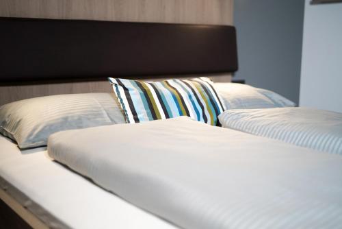 two beds with white sheets and pillows in a room at Max Lodging Serviced Apartments in Munich