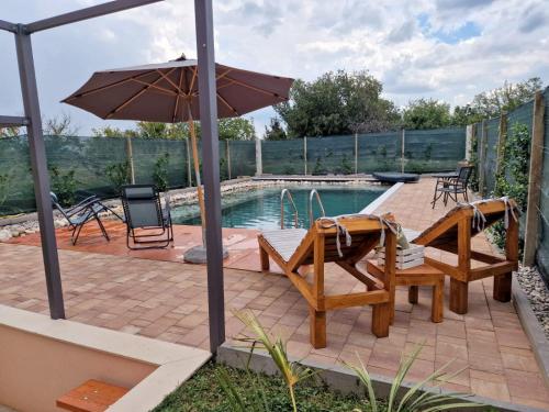 a patio with a table and chairs and an umbrella at Villa Bali - Aladinici in Stolac