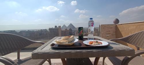 einen Tisch mit 2 Tellern Essen auf einem Balkon in der Unterkunft Bedouin Pyramids View in Kairo