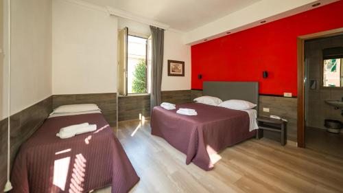 Habitación con 2 camas y pared roja. en Hotel Center 1 en Roma